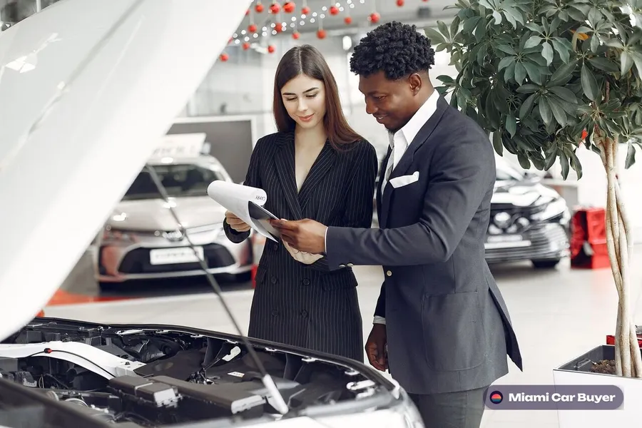 Person reviewing a Florida car title and dealer license paperwork before completing a vehicle sale