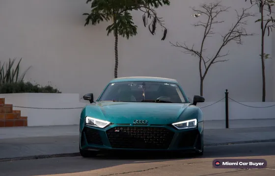 Teal Audi sedan parked against a wall, a typical luxury car sold for cash