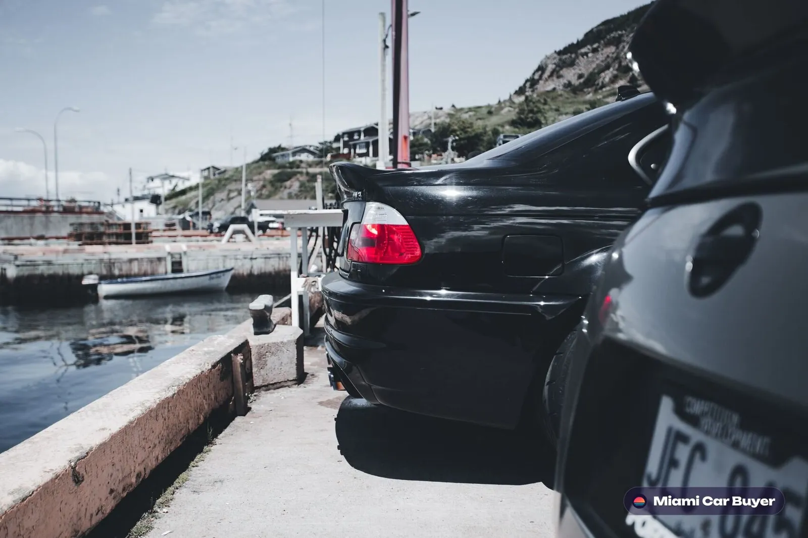 Black luxury sedan on a coastal Miami road - Florida title transfer guide by Miami Car Buyer