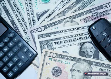 Car keys and cash dollar bills on a surface, representing the car sale transaction in the FAQ section