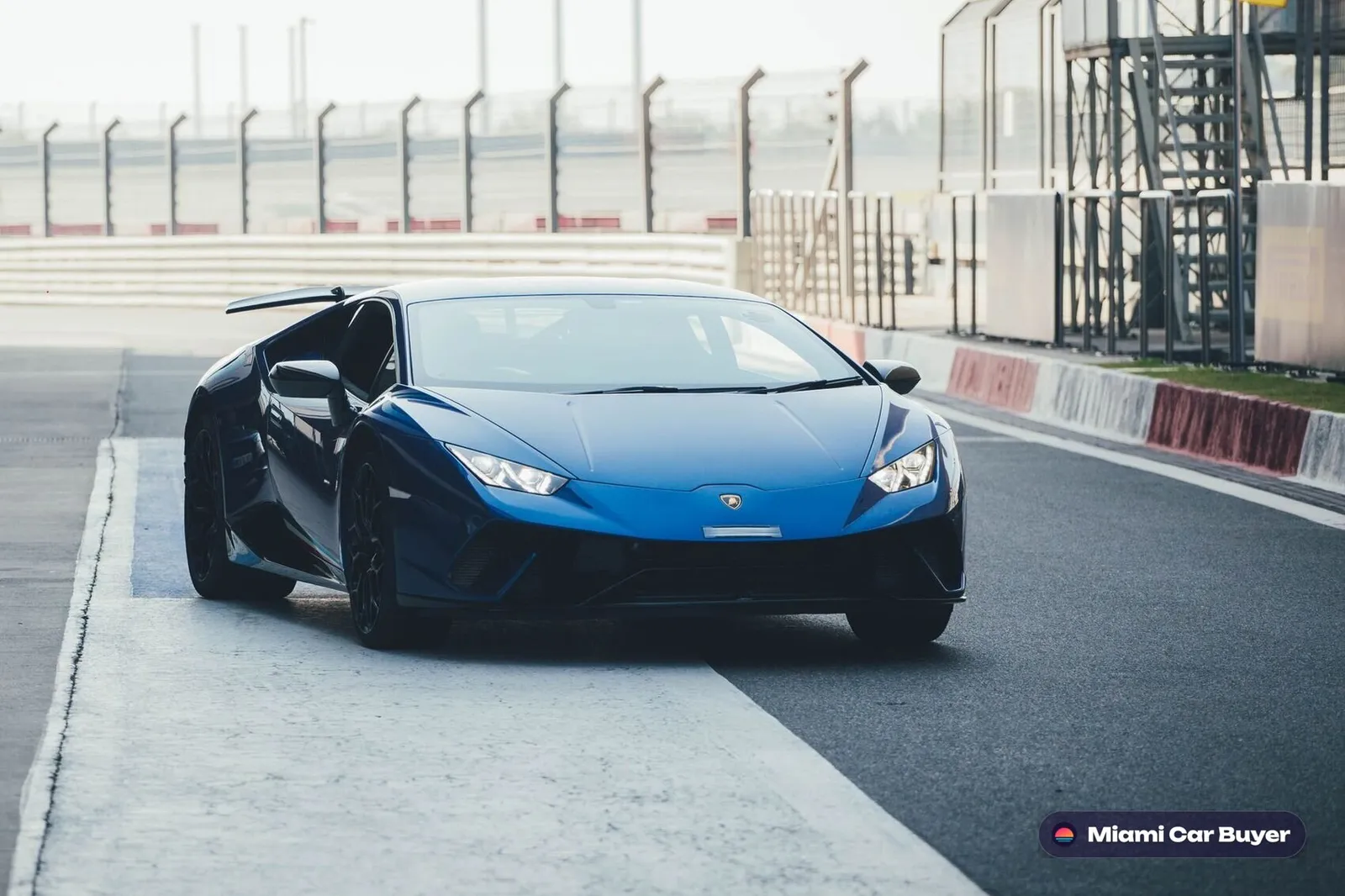 Silver-blue Lamborghini supercar on a race track, representing the quality and range of cars sold through Miami Car Buyer