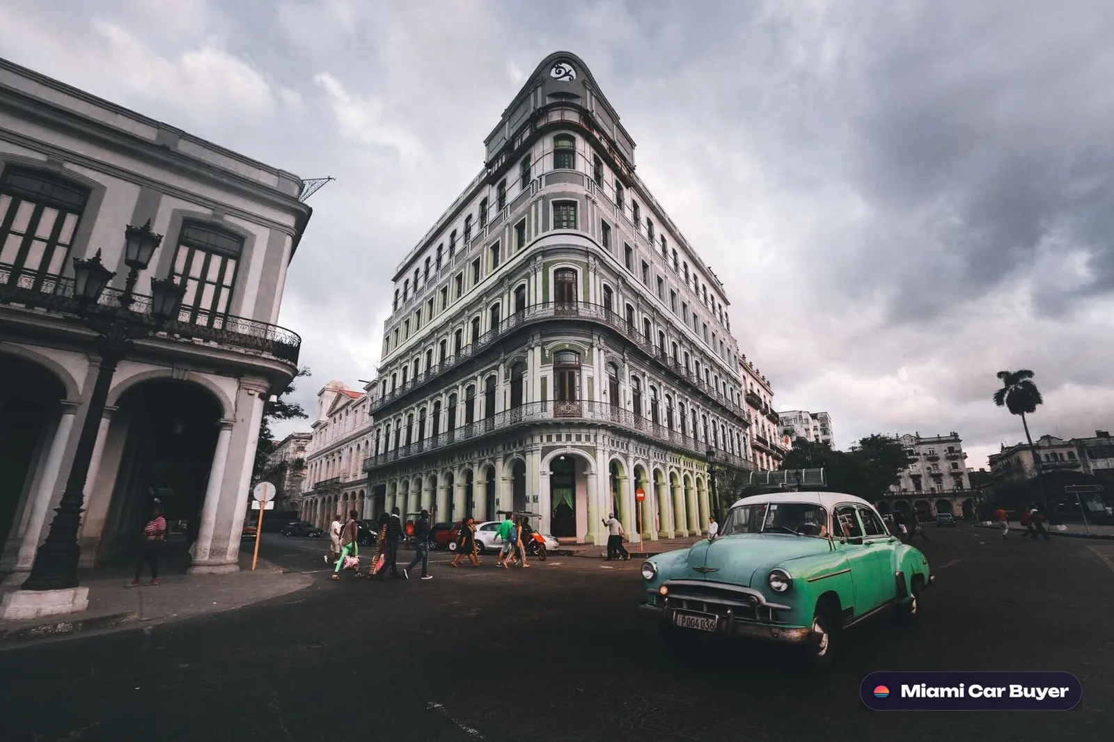 Vintage cars parked in front of a pastel art deco Miami facade, evoking classic Florida style