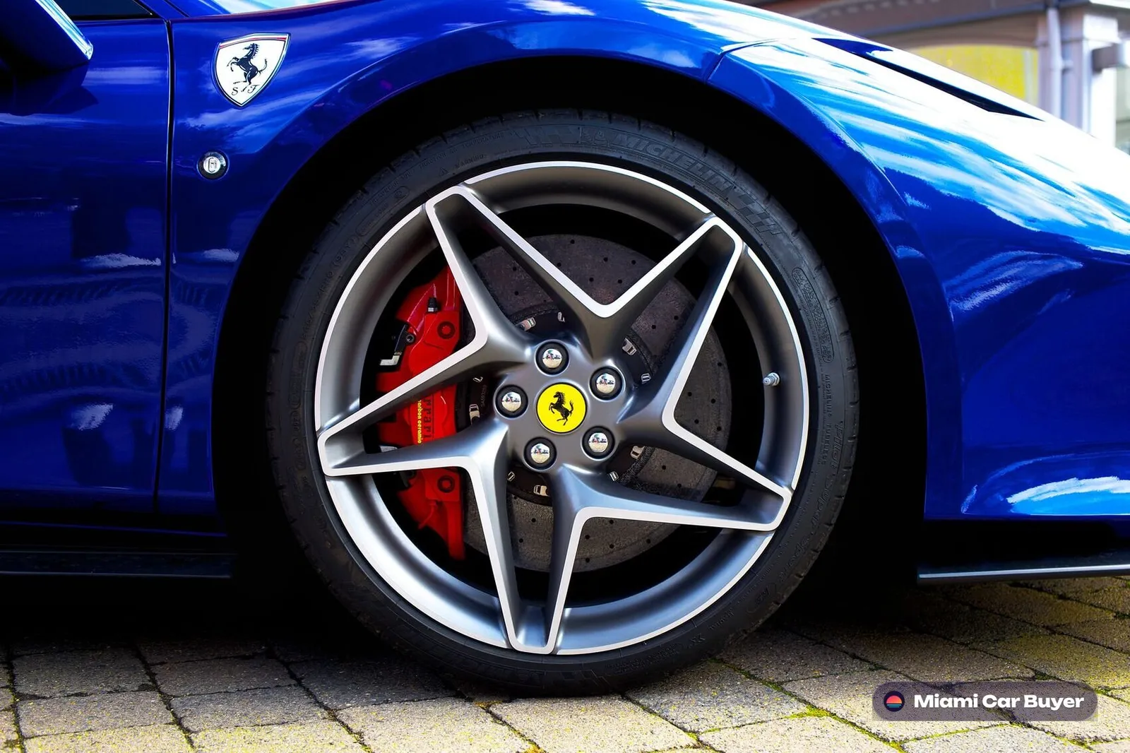Blue Ferrari wheel and brake caliper detail - your flood car sells for cash through Miami Car Buyer