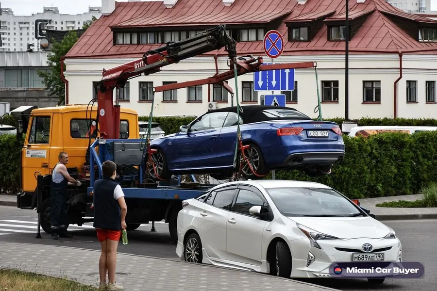 Tow truck collecting a car from a Coral Gables driveway