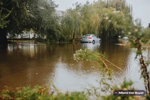 Flood-damaged junk car submerged in water in Miami, illustrating the kind of cars Miami Car Buyer purchases