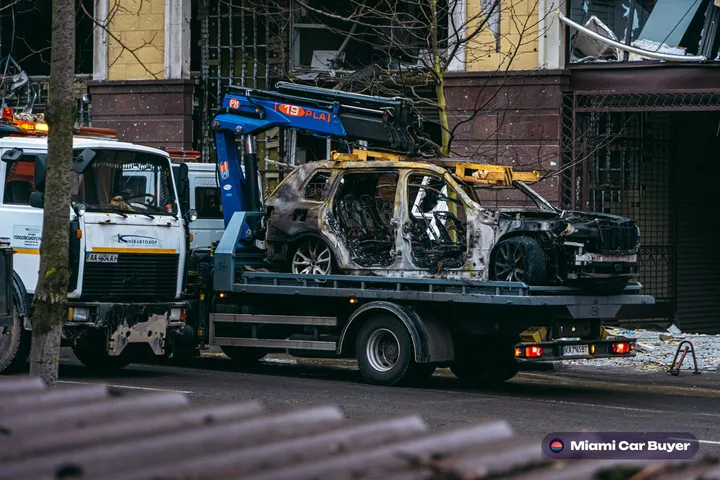 Flatbed tow truck loading a car on a Miami street during same-day pickup